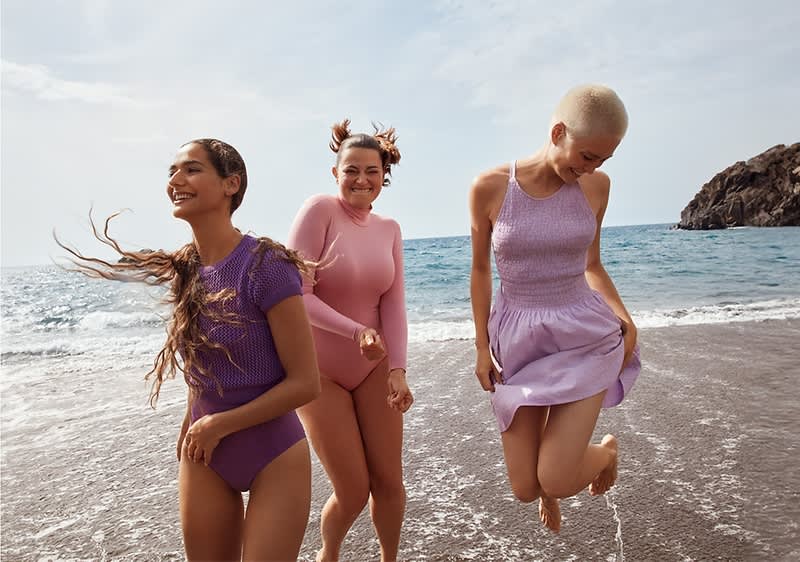 Lachende, tanzende Frauen am Strand