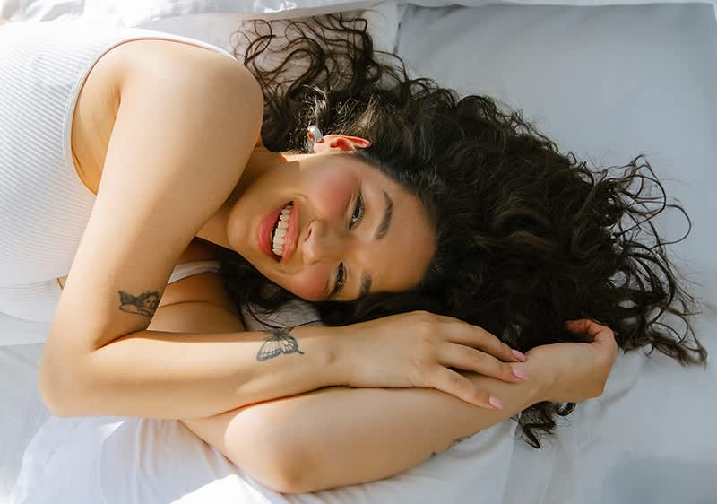 Eine lachende Frau im Bett