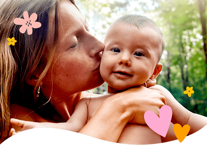 Mutter mit Baby im Freien umgeben von Pflanzen und Blumen