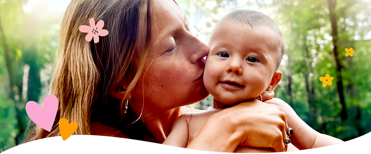 Mutter mit Baby im Freien umgeben von Pflanzen und Blumen