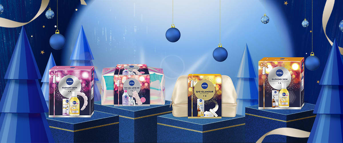 Подаръчни комплекти Nivea на син фон с коледни декорации