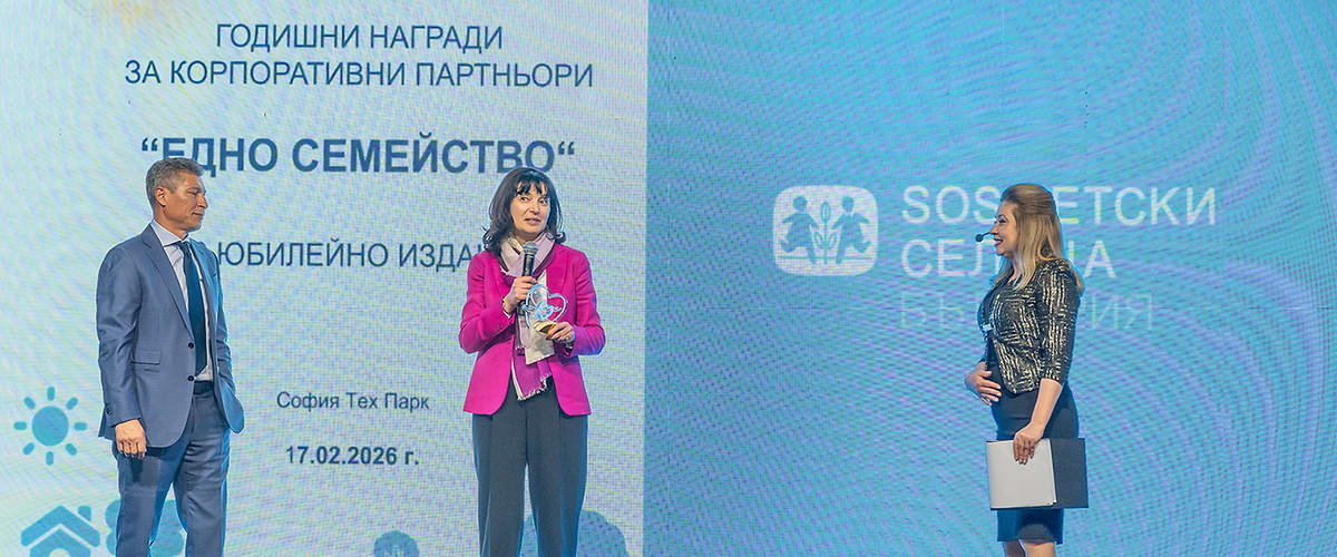 На изображението има трима души на сцена по време на събитие.