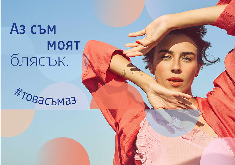 Жена позира на открито, облечен в червена риза, с ръце над главата.