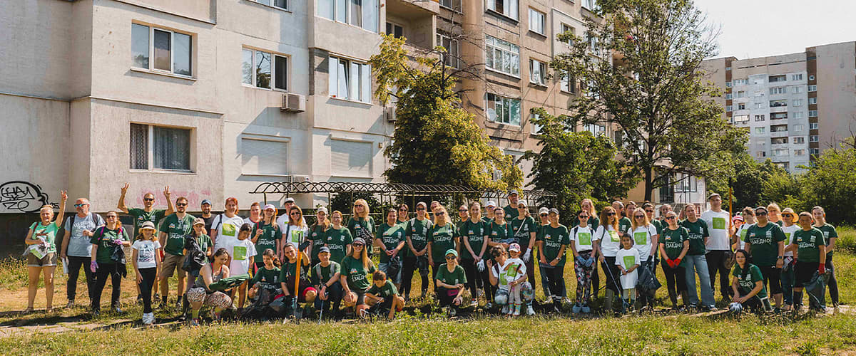 Група доброволци пред жилищна сграда в зелена градска площ