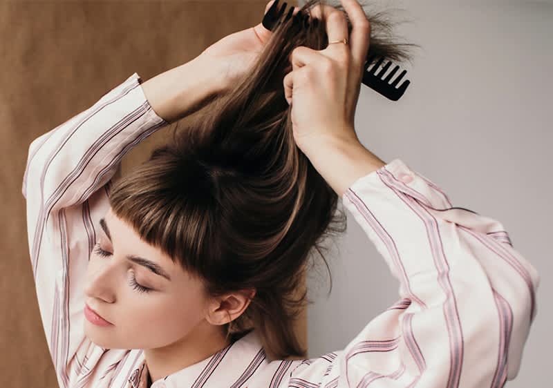 Frau kämmt sich Haare
