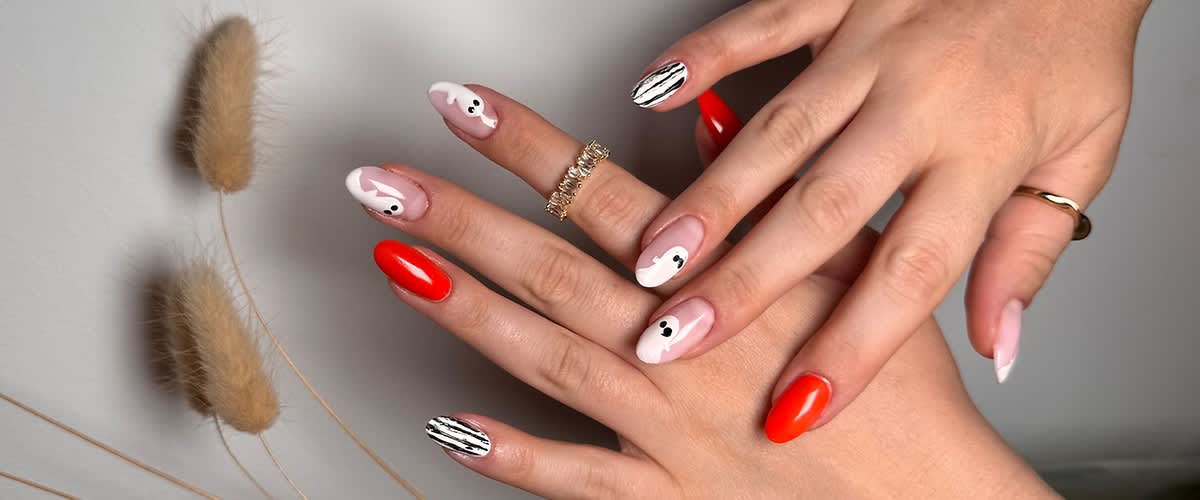 Nageldesign mit roten und schwarz-weiß gestreiften Nägeln und Geist-Mustern