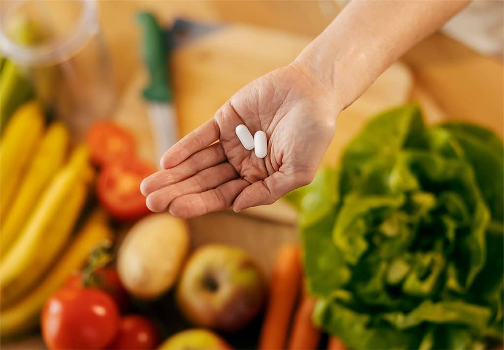 Žena u ruci drži dodatak prehrani u obliku tableta