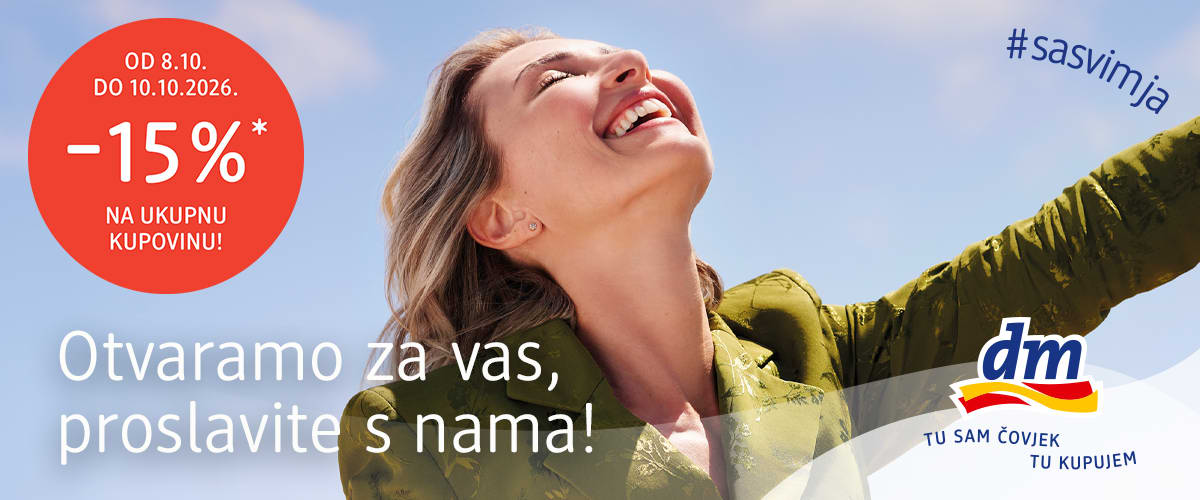 Žena u zelenoj jakni raširenih ruku smiješeći se na otvorenom