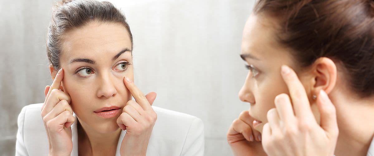 djevojka koja proučava svoje podočnjake u ogledalu