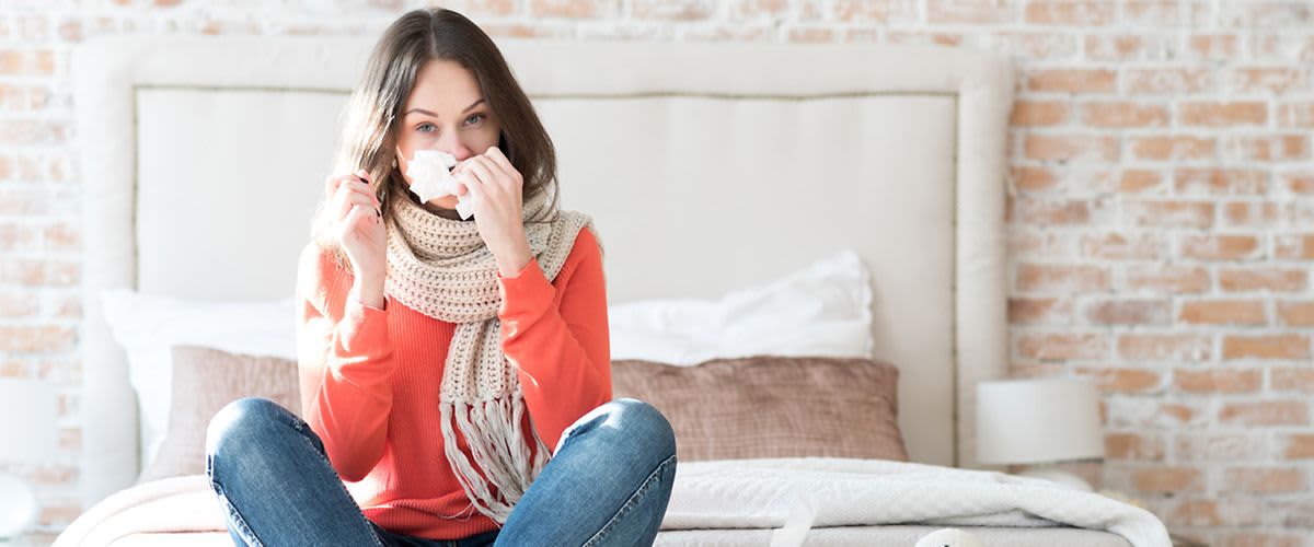 Žena si čisti nos s maramicom