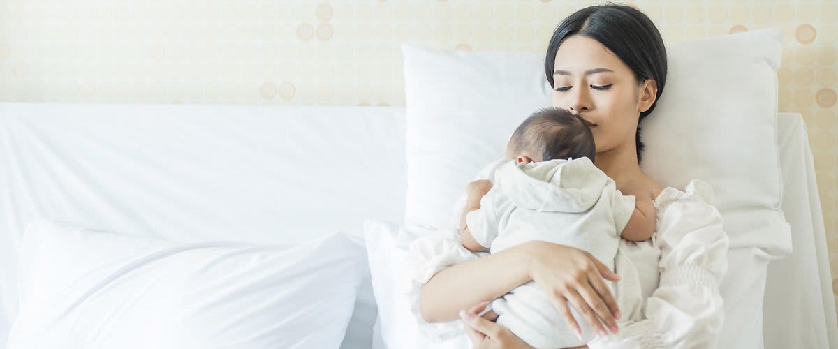 Žena s bebom u zagrljaju