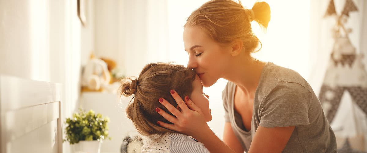 mama koja ljubi dijete prije spavanja