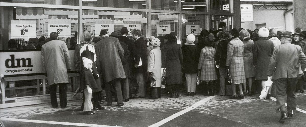 Menschen warten neugierig vor der ersten dm Filiale in Linz.