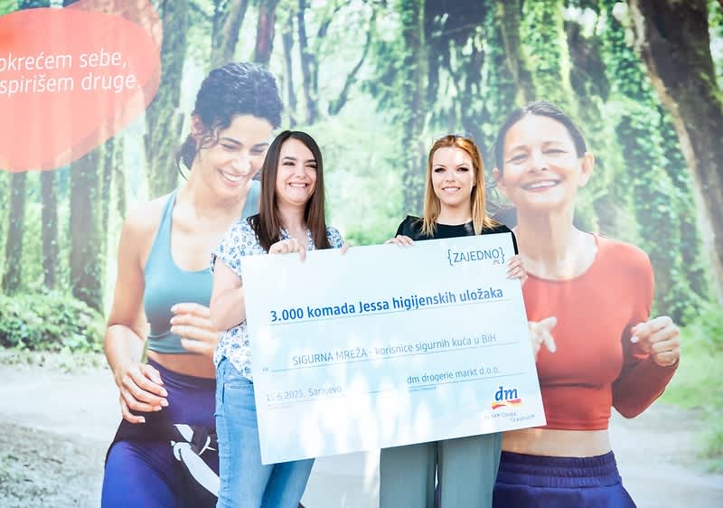 Dvije žene drže ček za donaciju