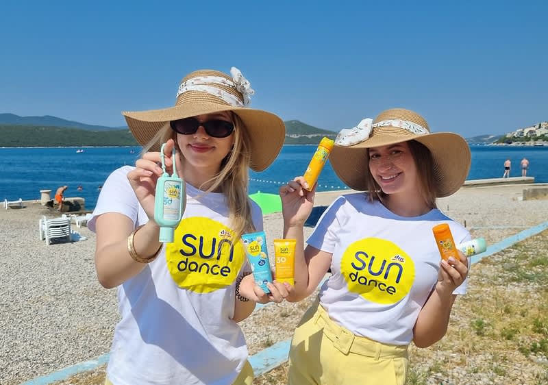 Dvije djevojke na plaži sa šeširima i SUNDANCE kremama za sunčanje