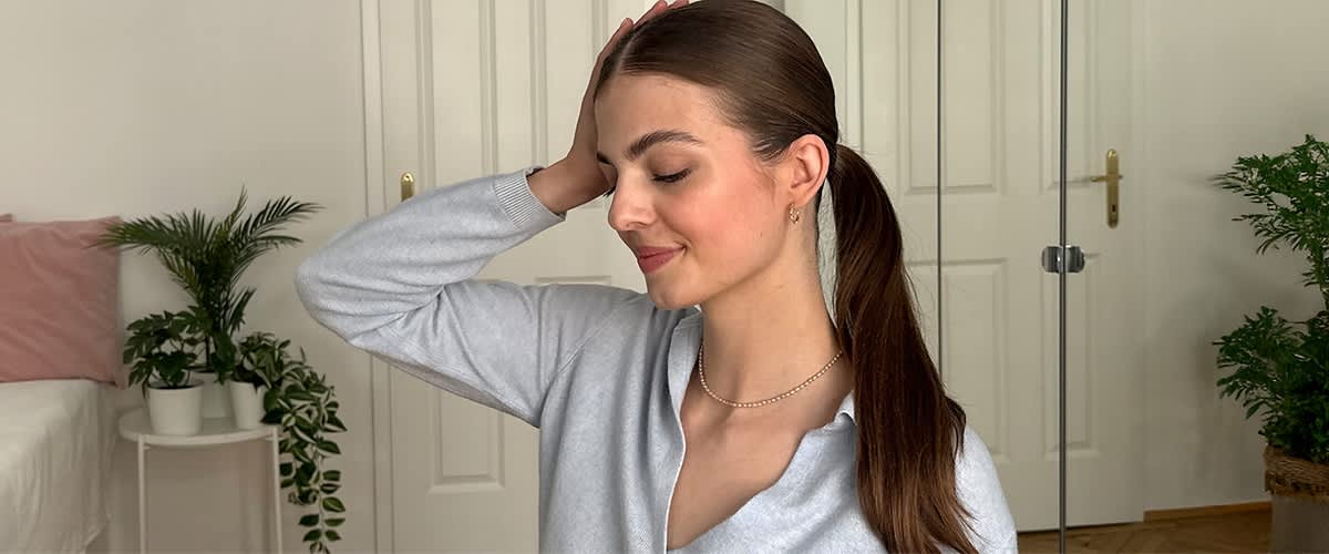 Žena s dugim repom ispred bijelih vrata