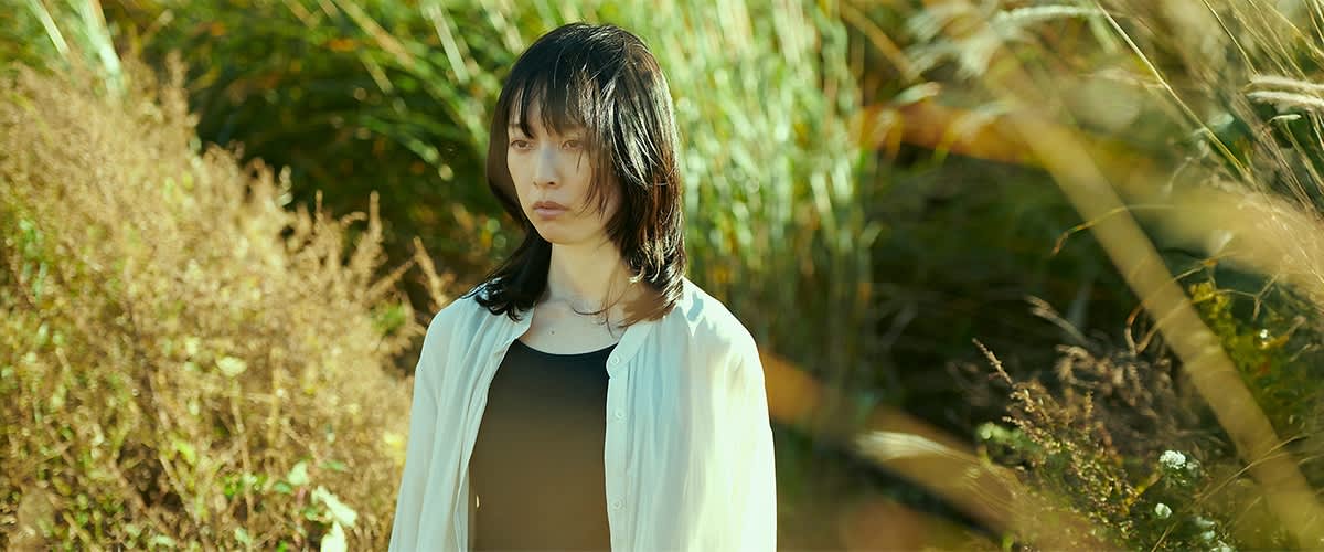 Žena u bijeloj bluzi na zelenoj pozadini