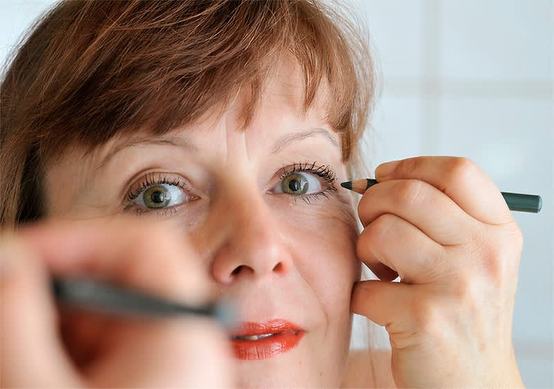 Žena nanosi olovku za oči