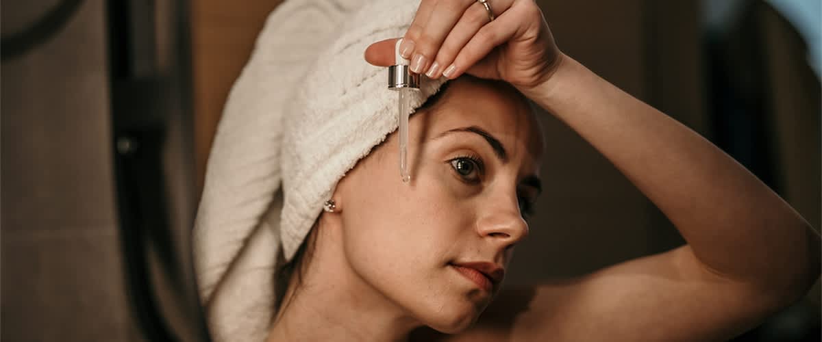 Žena nanosi serum na lice