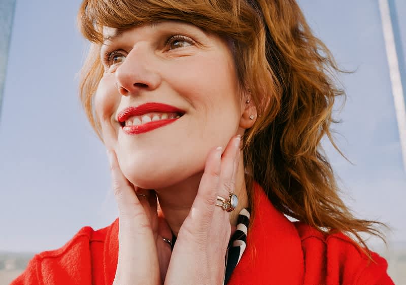 Žena u crvenom sa cvrenim ružem na usnama