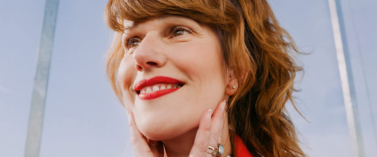 Žena u crvenom sa cvrenim ružem na usnama