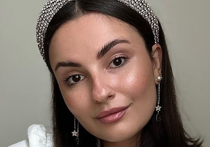 Eine Person trägt ein glitzerndes Haarband und lange Ohrringe mit einem Sternanhänger