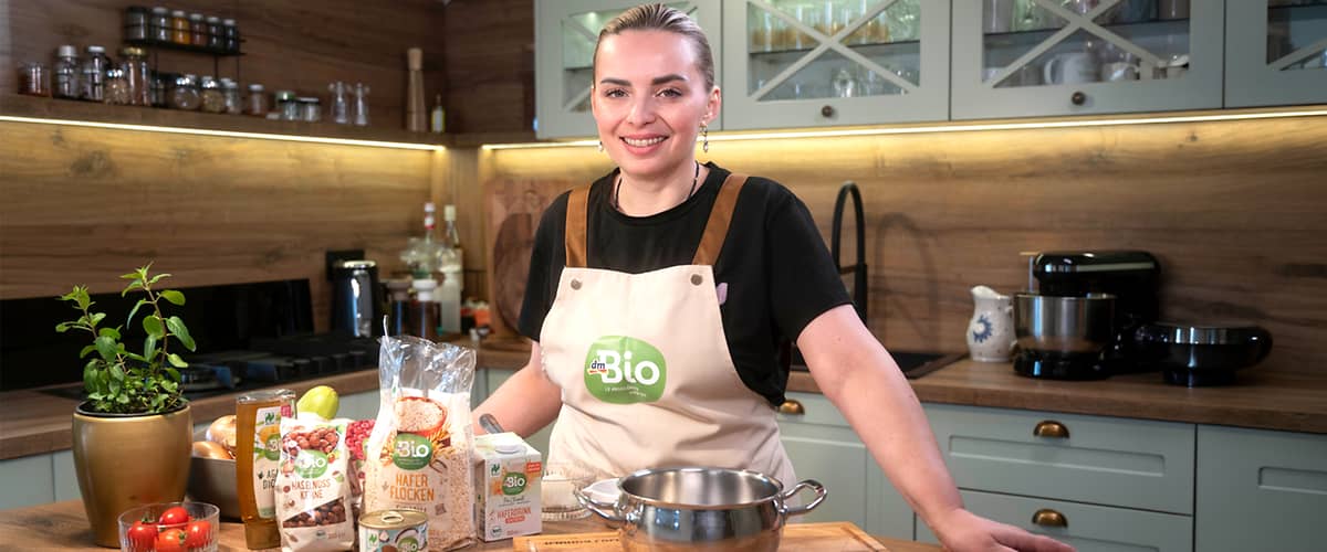 Selma Karić u kuhinji s bio proizvodima na drvenom pultu.