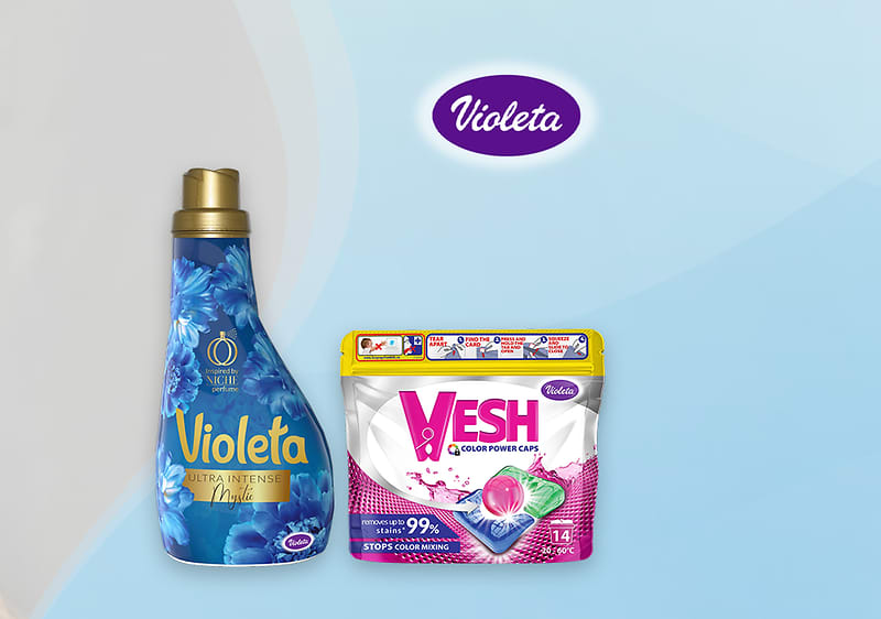 Dva deterdženta Violeta bočica i vrećica kapsula na plavoj pozadini