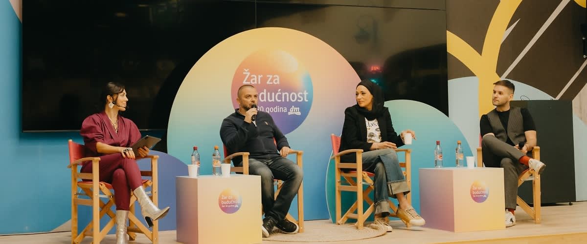 Glavna ključna riječ: panelAlt-tekst: Panel rasprava s četvero sudionika na pozornici i pozadinom događaja