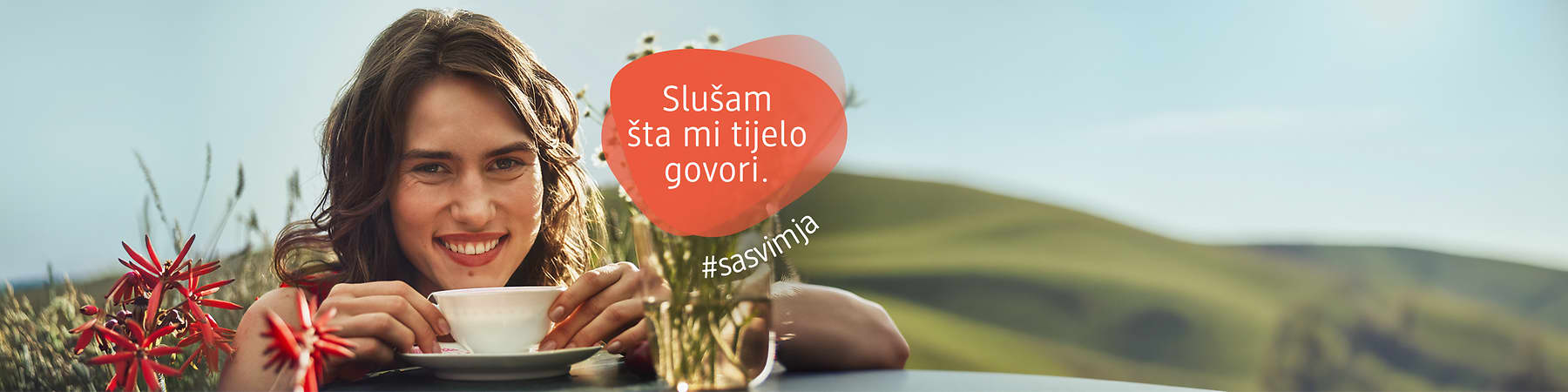 Žena s osmijehom pije čaj u vrtu uz natpis Slušam šta mi tijelo govori