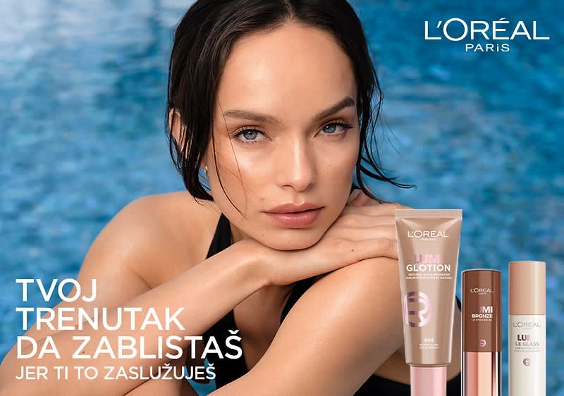 Ženski model pored kozmetičkih proizvoda L'Oréal uz plavo more