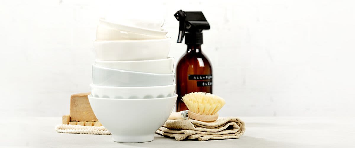 Bílé misky na sobě a hnědá láhev s rozprašovačem