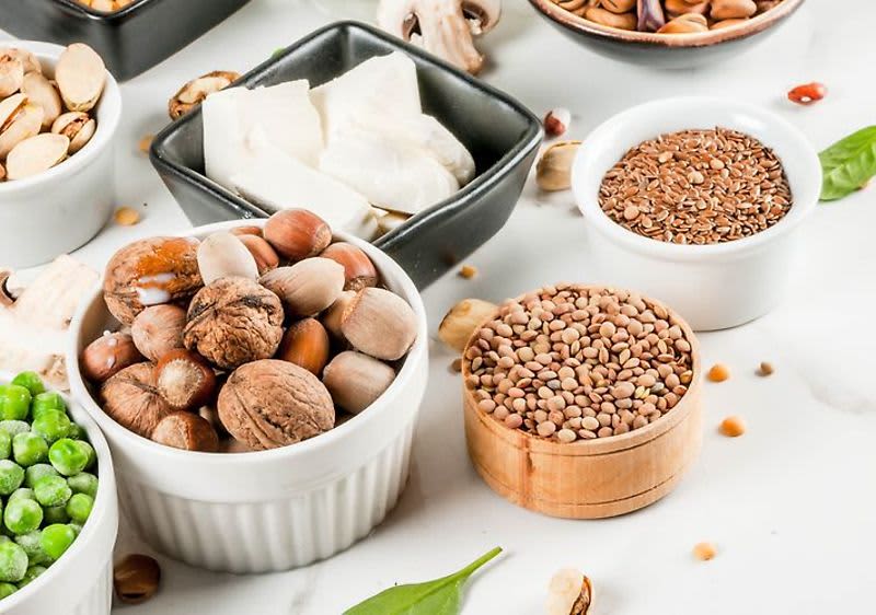 Ořechy, semínka, hrášek, sýr a houby na bílém pozadí