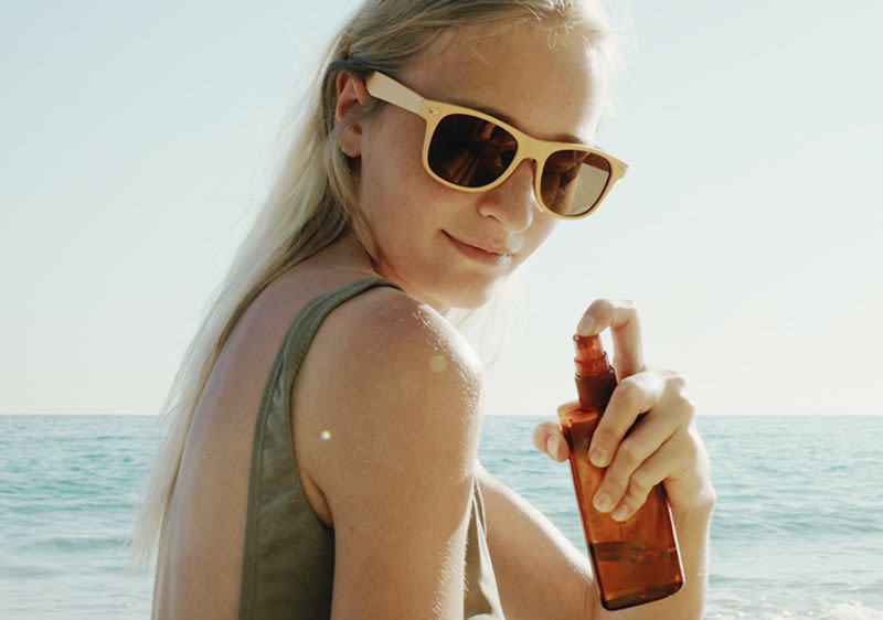 žena s SPF sprejem u moře