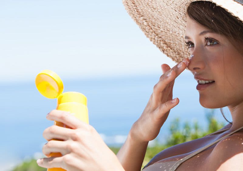 žena si nanáší opalovací krém na obličej