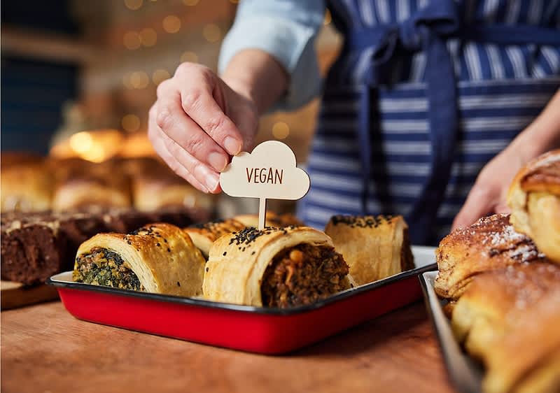 Pečivo s náplní označené cedulkou vegan na pultu v pekárně