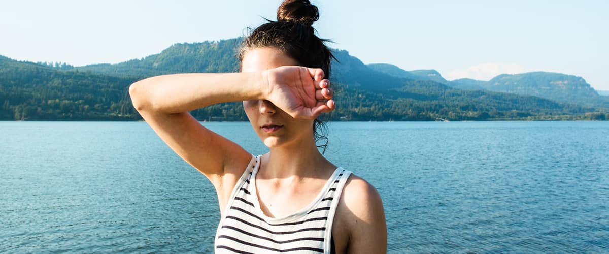 Žena u jezera s horami v pozadí