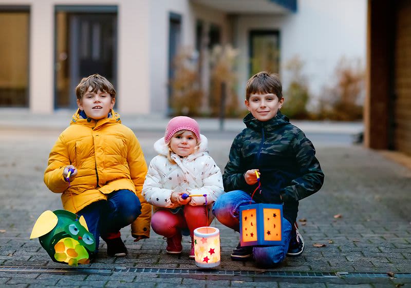Děti s lampionmi sedící na ulici