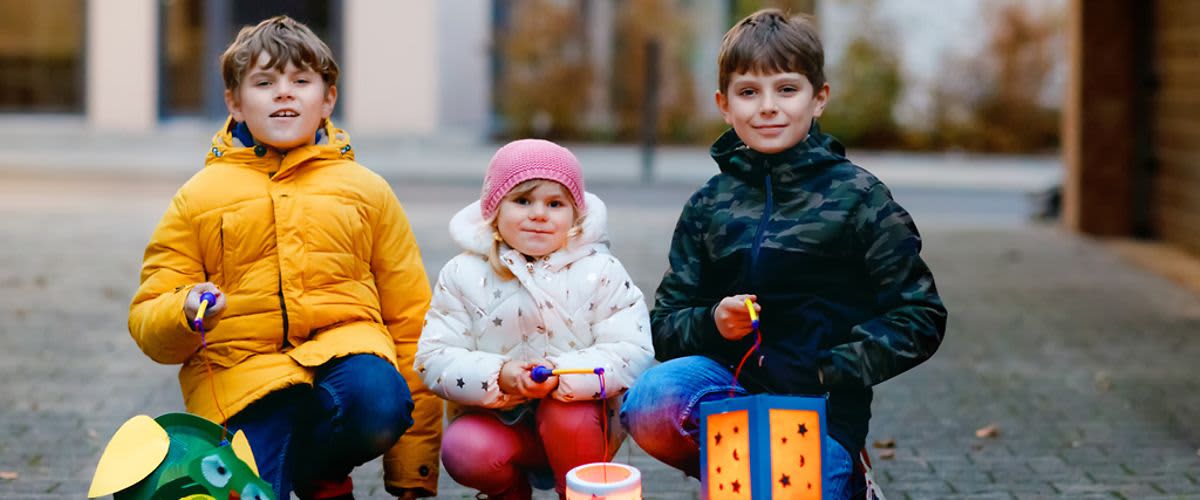 Děti s lampionmi sedící na ulici