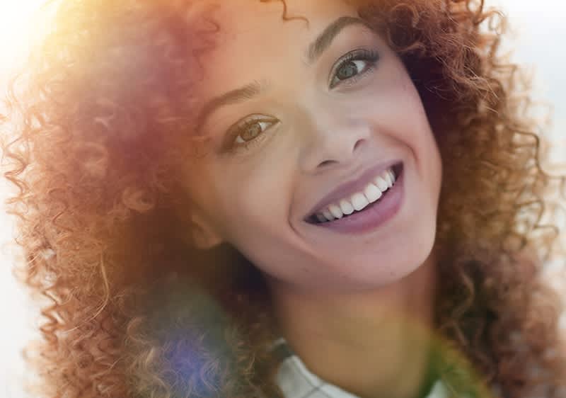 Kudrnaté vlasy s barevnými odlesky na světle