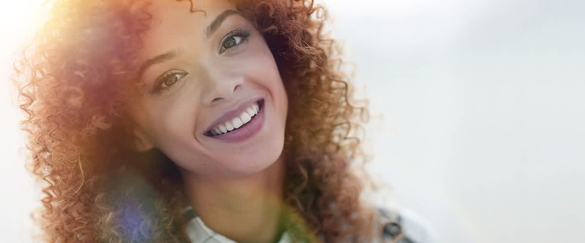 Kudrnaté vlasy s barevnými odlesky na světle