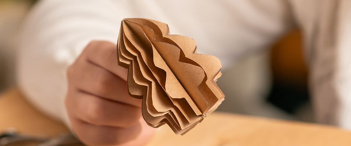 Papírový stromek držený rukou