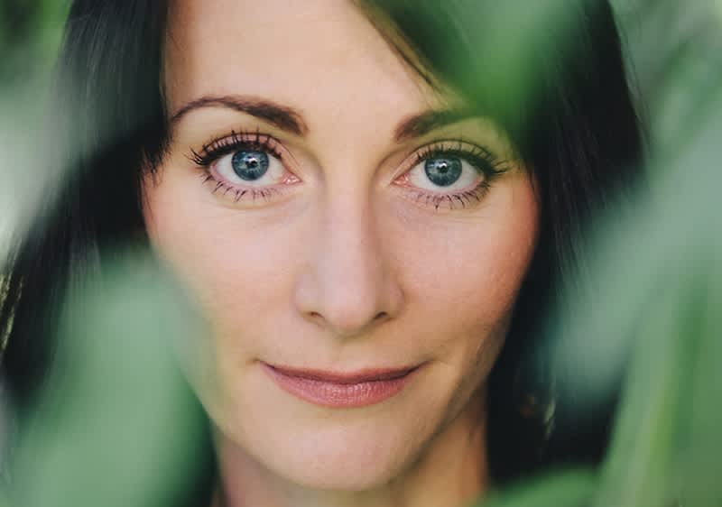 Žena obklopená zelenými listy