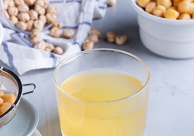 Sklenice s cizrnovou vodou, cizrna v sítku, cizrna na utěrce, miska s cizrnou
