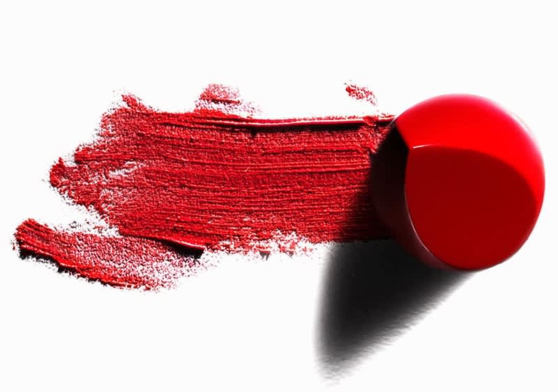 Červená rtěnka rozmazaná na bílém pozadí