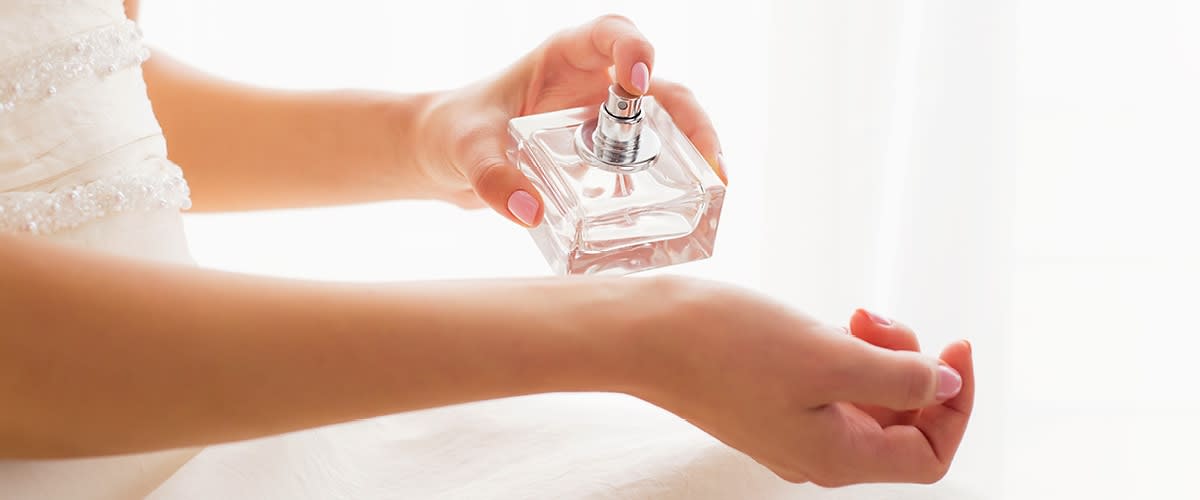 Ruka stříkající parfém na zápěstí
