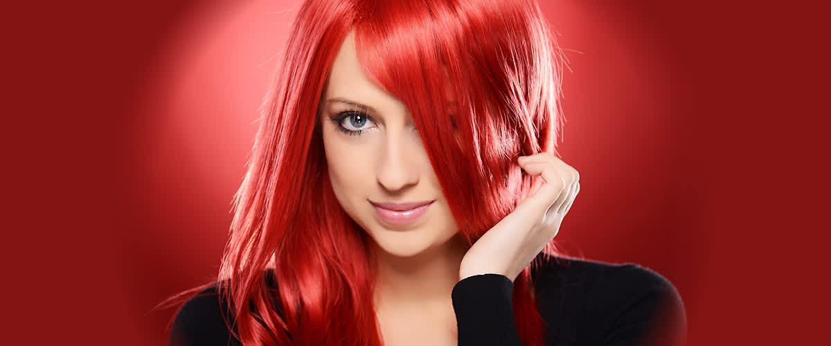 Žena s dlouhými červenými vlasy na červeném pozadí