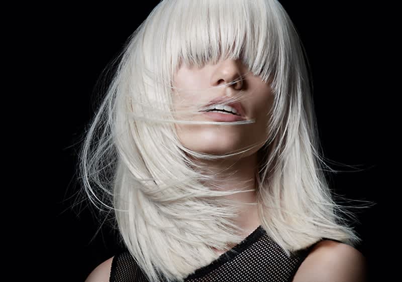 Žena s platinově blond vlasy na černém pozadí