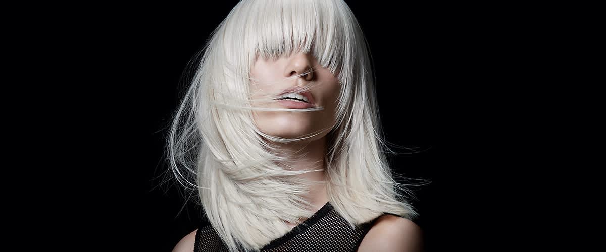 Žena s platinově blond vlasy na černém pozadí