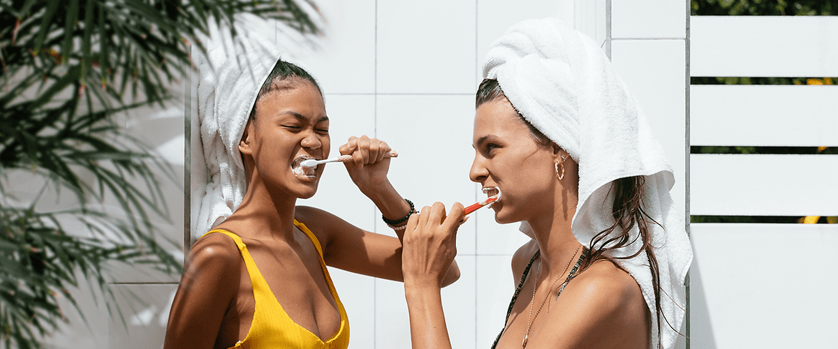 Dvě ženy v plavkách s ručníky na hlavách u bazénu